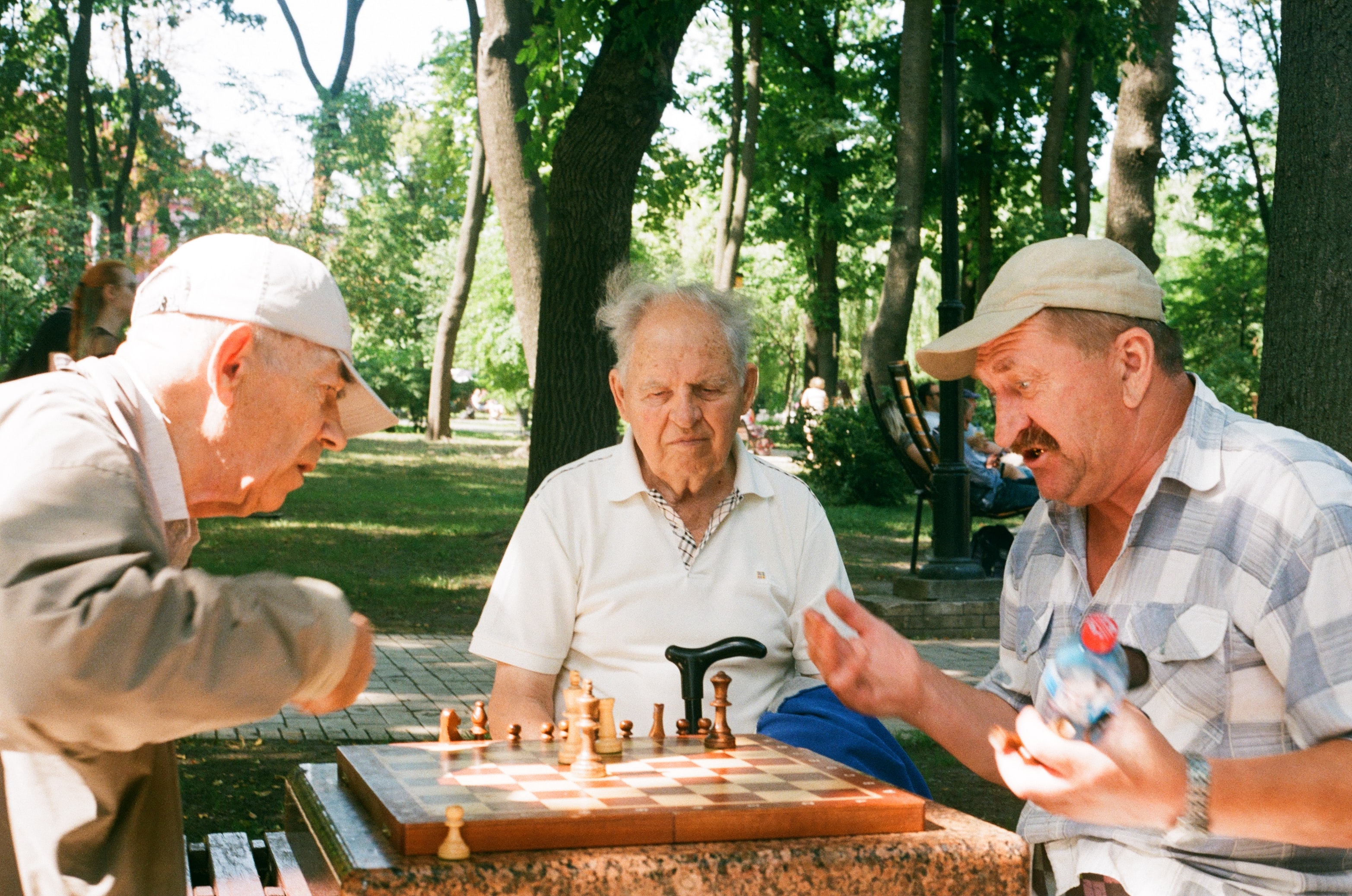 three old man sitting and playing on a table
